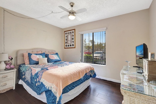 bedroom with wood finish floors, a textured ceiling, baseboards, and a ceiling fan