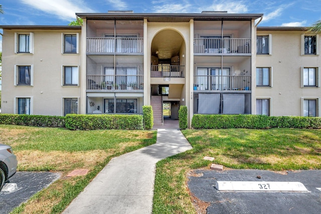 view of apartment building / complex featuring uncovered parking