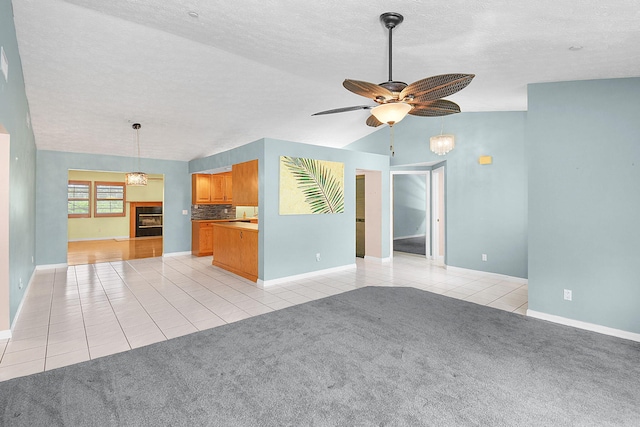 895 SE Waterside Way, Stuart, FL 34997 - unfurnished living room featuring light tile patterned floors, a ceiling fan, baseboards, a textured ceiling, and lofted ceiling
