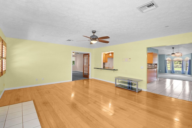895 SE Waterside Way, Stuart, FL 34997 - unfurnished living room with hardwood / wood-style flooring, ceiling fan, a textured ceiling, and baseboards