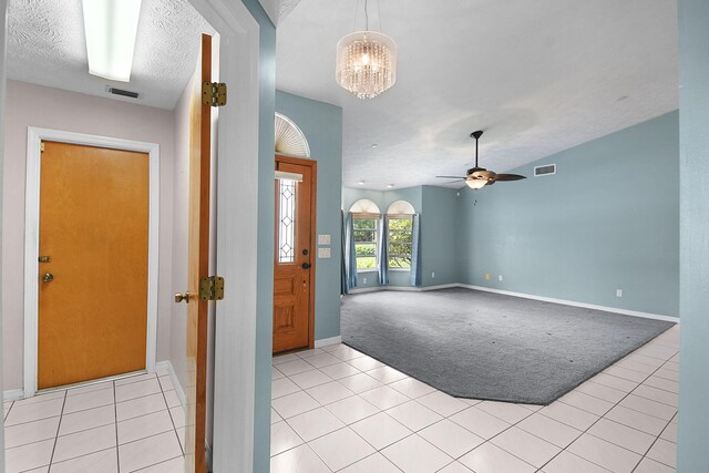 895 SE Waterside Way, Stuart, FL 34997 - entryway with light tile patterned floors, light colored carpet, baseboards, a chandelier, and a ceiling fan