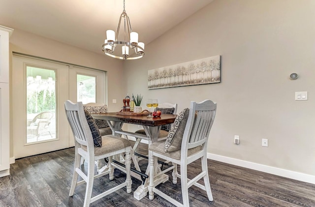 dining room featuring a chandelier, dark wood-style flooring, baseboards, and lofted ceiling