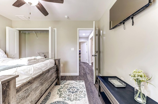 bedroom with wood finished floors, a closet, baseboards, and a ceiling fan