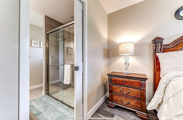 bathroom featuring a shower stall, wood finished floors, and baseboards