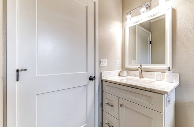 bathroom with vanity and a textured wall