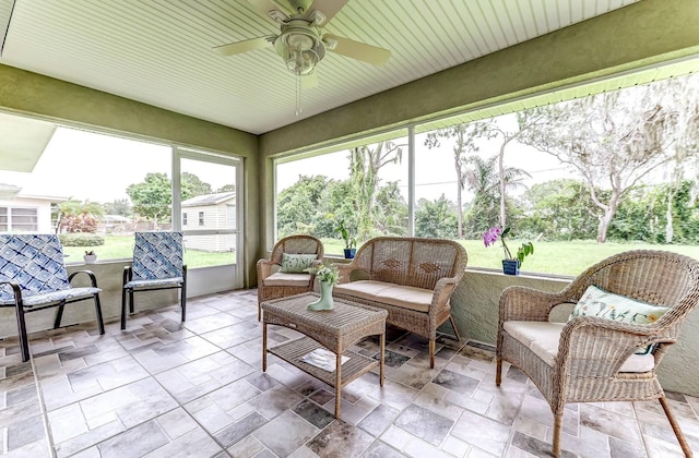 sunroom / solarium featuring a ceiling fan and an outdoor hangout area