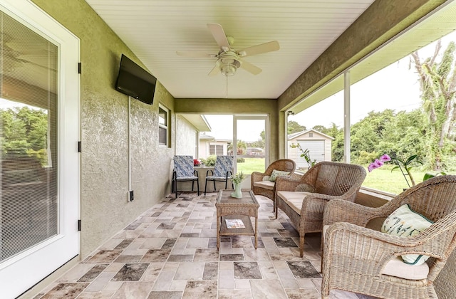 sunroom with a ceiling fan and an outdoor hangout area