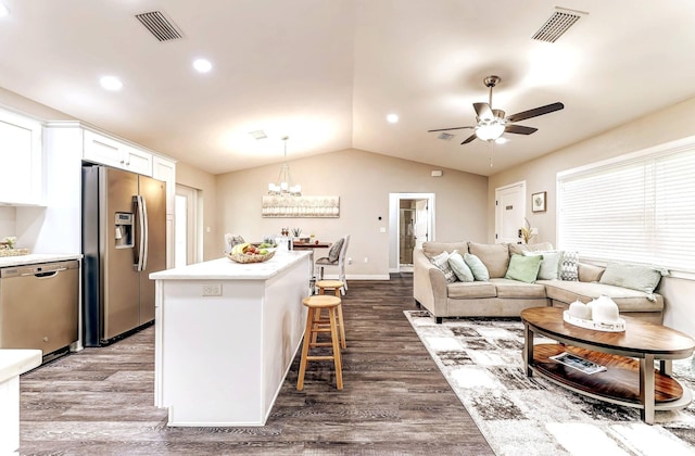 living area featuring dark wood-style flooring, ceiling fan, lofted ceiling, a chandelier, and baseboards