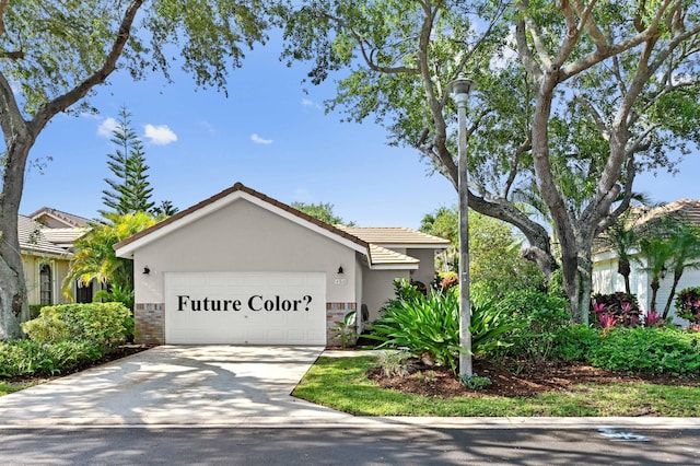 single story home featuring stucco siding, a garage, a tiled roof, and concrete driveway