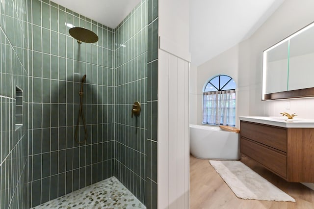 full bathroom with wood finished floors, a freestanding bath, vanity, and a tile shower