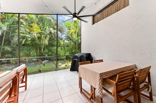 sunroom featuring a ceiling fan and outdoor dining area