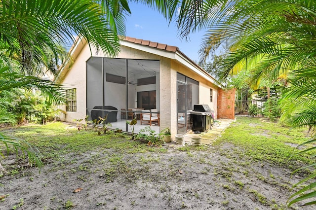 view of outbuilding with a sunroom and fence