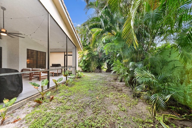 view of yard with a patio area, a ceiling fan, and an outdoor living space