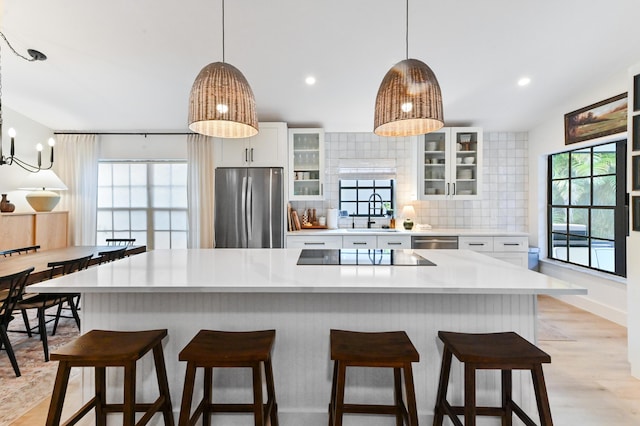 kitchen with appliances with stainless steel finishes, decorative backsplash, light countertops, white cabinetry, and recessed lighting