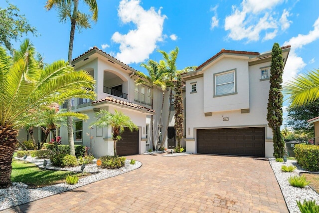 682 Cresta Cir, West Palm Beach, FL 33413 - mediterranean / spanish-style house with an attached garage, a balcony, stucco siding, decorative driveway, and a tiled roof
