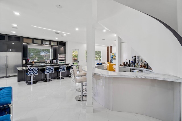 682 Cresta Cir, West Palm Beach, FL 33413 - indoor dry bar with built in fridge, recessed lighting, and light tile patterned floors