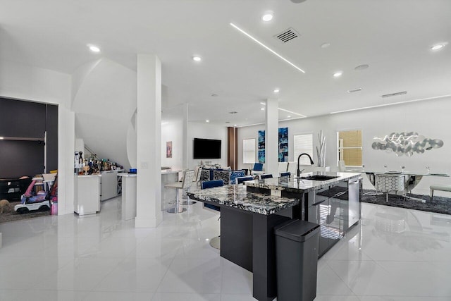 682 Cresta Cir, West Palm Beach, FL 33413 - kitchen featuring a sink, dark stone counters, a center island with sink, open floor plan, and recessed lighting