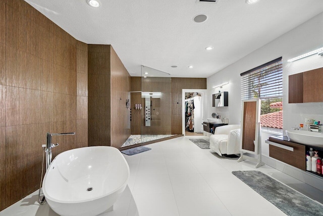 682 Cresta Cir, West Palm Beach, FL 33413 - bathroom with walk in shower, a freestanding tub, a sink, recessed lighting, and tile walls