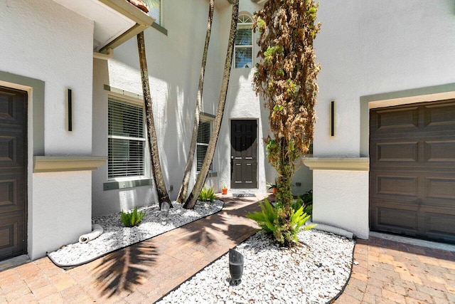 682 Cresta Cir, West Palm Beach, FL 33413 - view of exterior entry featuring stucco siding and a garage
