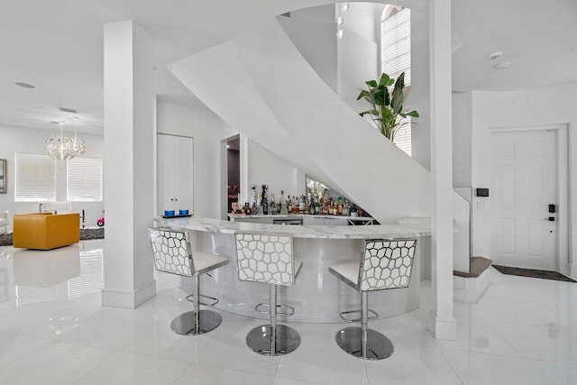 682 Cresta Cir, West Palm Beach, FL 33413 - indoor dry bar with tile patterned floors, baseboards, and a chandelier
