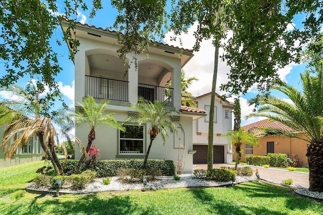 682 Cresta Cir, West Palm Beach, FL 33413 - view of front of home with a balcony, stucco siding, a garage, driveway, and a tiled roof