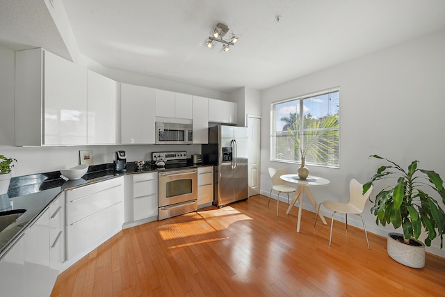 11011 Legacy Ln Unit 306, Palm Beach Gardens, FL 33410 - kitchen with appliances with stainless steel finishes, modern cabinets, dark countertops, white cabinets, and light wood-type flooring