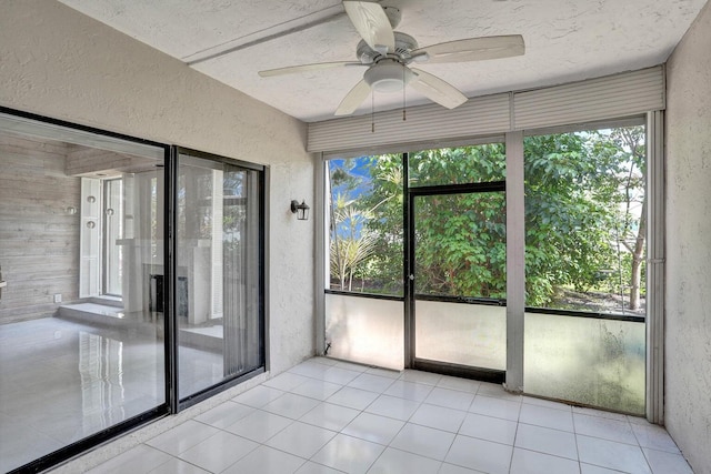 unfurnished sunroom with plenty of natural light and a ceiling fan