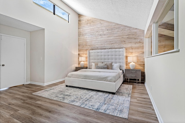22924 Ironwedge Dr, Boca Raton, FL 33433 - bedroom featuring wooden walls, high vaulted ceiling, a textured ceiling, wood finished floors, and baseboards