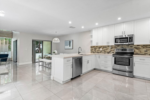 22924 Ironwedge Dr, Boca Raton, FL 33433 - kitchen with stainless steel appliances, a peninsula, a sink, open shelves, and backsplash