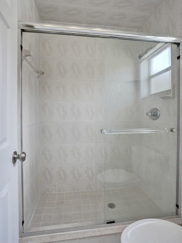 bathroom featuring a shower stall and toilet