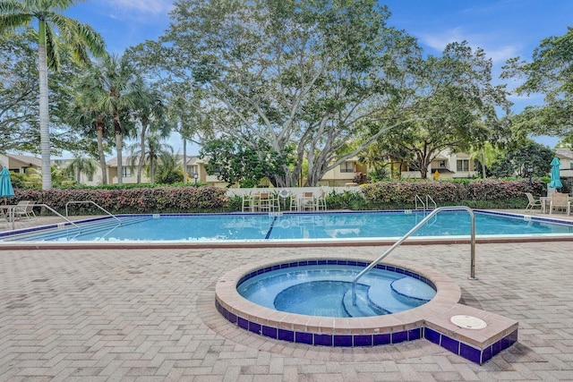 community pool with a hot tub