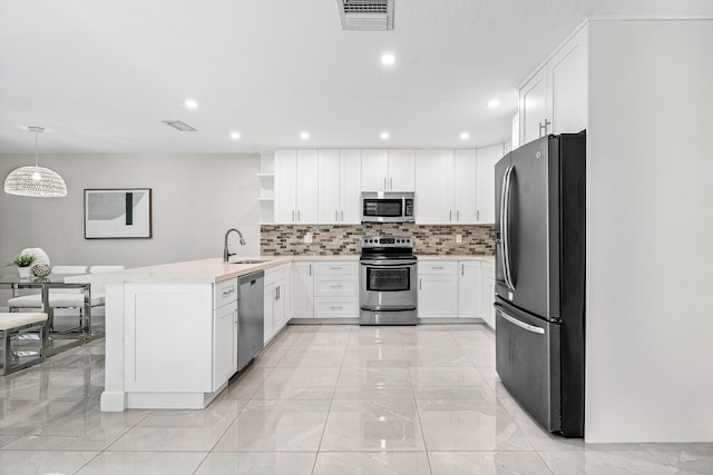 22924 Ironwedge Dr, Boca Raton, FL 33433 - kitchen with appliances with stainless steel finishes, a sink, light marble finish flooring, a peninsula, and white cabinetry