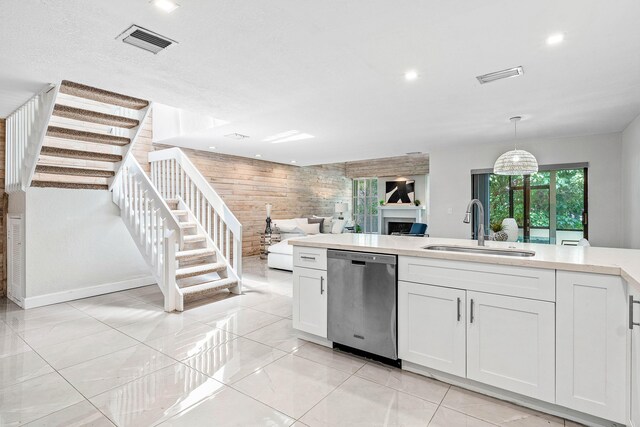22924 Ironwedge Dr, Boca Raton, FL 33433 - kitchen with stainless steel dishwasher, a sink, white cabinets, light countertops, and a fireplace