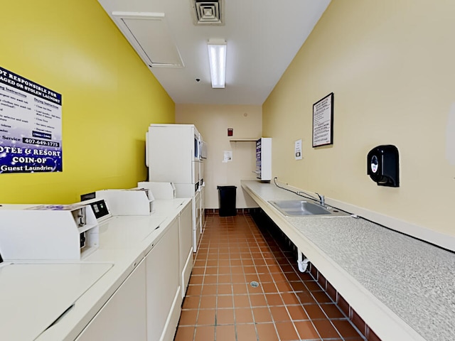 3100 Parkway Blvd Unit 310, Kissimmee, FL 34747 - communal laundry room with washer and dryer, dark tile patterned floors, and attic access
