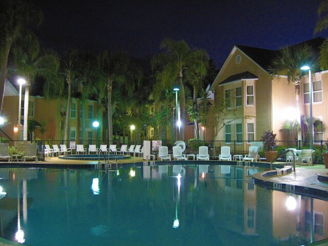 3100 Parkway Blvd Unit 310, Kissimmee, FL 34747 - pool at night featuring fence and a community pool