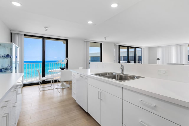 3360 S Ocean Blvd Unit 5Fii, Palm Beach, FL 33480 - kitchen with white dishwasher, a sink, light countertops, white cabinetry, and light wood-type flooring