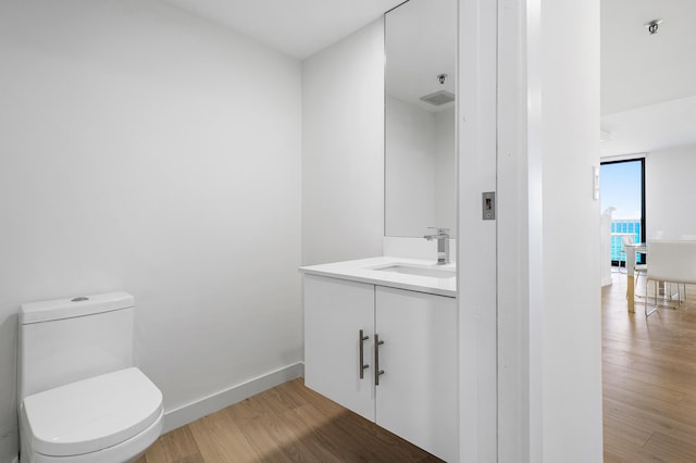 3360 S Ocean Blvd Unit 5Fii, Palm Beach, FL 33480 - half bath featuring wood finished floors, toilet, vanity, and baseboards