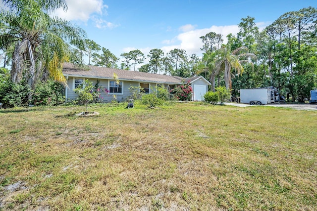 ranch-style house with a front yard, a garage, and a storage unit