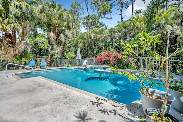 view of pool featuring fence, a patio area, and a pool with connected hot tub