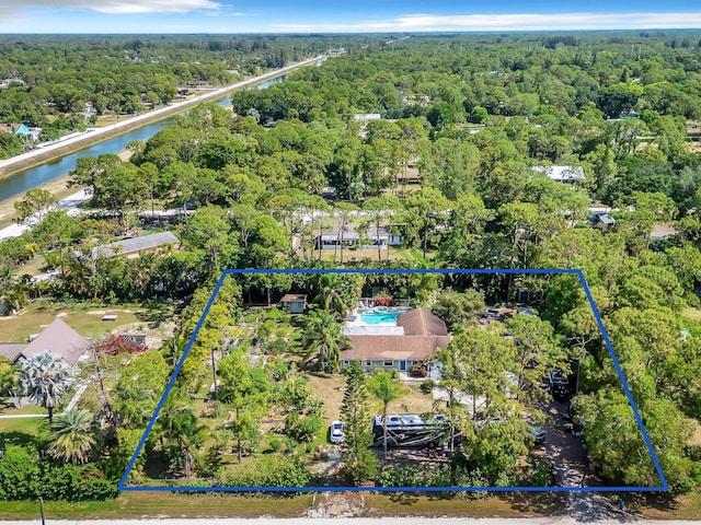 aerial overview of property's location with property parcel outlined, a heavily wooded area, and a large body of water