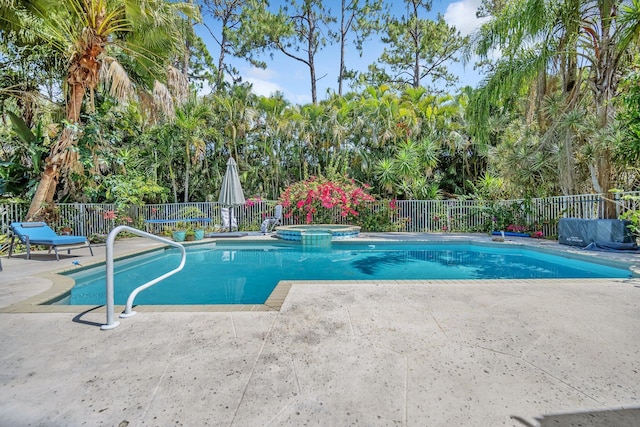 view of pool featuring fence, a patio area, and a pool with connected hot tub