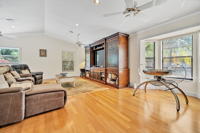 living area featuring a ceiling fan, a textured ceiling, wood finished floors, vaulted ceiling, and ornamental molding