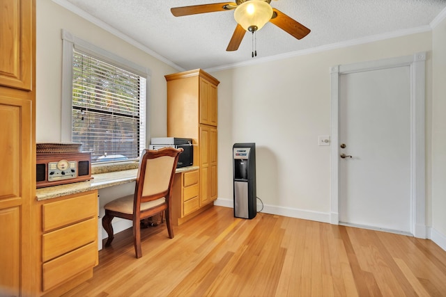 office area featuring light wood finished floors, ceiling fan, a textured ceiling, crown molding, and baseboards