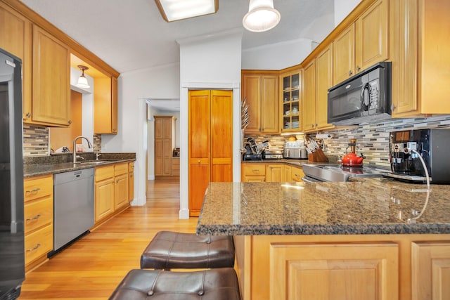 kitchen featuring stainless steel dishwasher, black microwave, a sink, crown molding, and light wood-type flooring