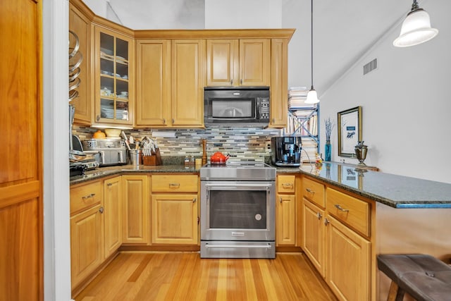 kitchen with black microwave, stainless steel electric range oven, a peninsula, light wood-style flooring, and decorative backsplash