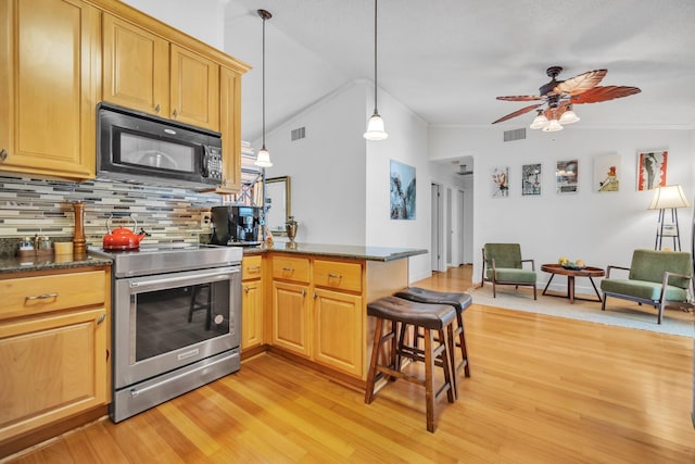 kitchen featuring electric stove, black microwave, a peninsula, light wood finished floors, and backsplash