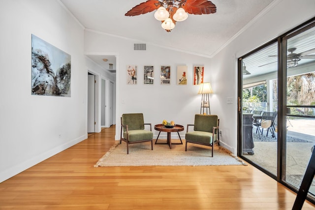 sitting room with crown molding, lofted ceiling, a ceiling fan, light wood finished floors, and baseboards