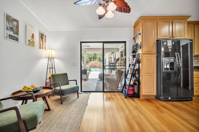 sitting room with a ceiling fan, light wood-style floors, and ornamental molding