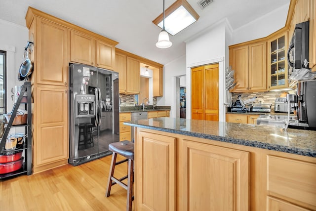 kitchen featuring black appliances, crown molding, light wood finished floors, decorative backsplash, and glass insert cabinets