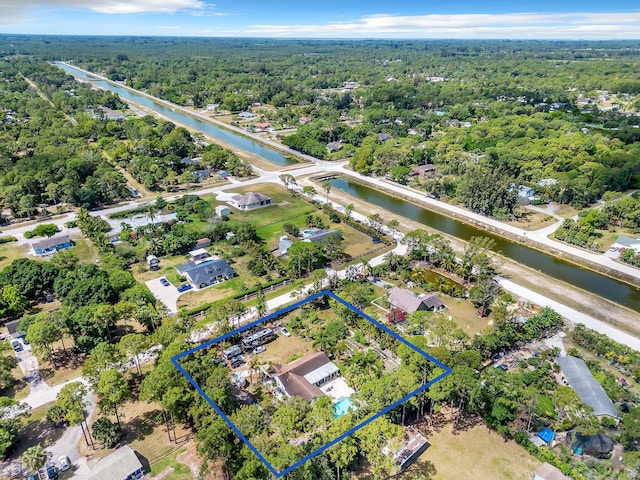 aerial view of property's location featuring property boundaries highlighted, a nearby body of water, and a forest